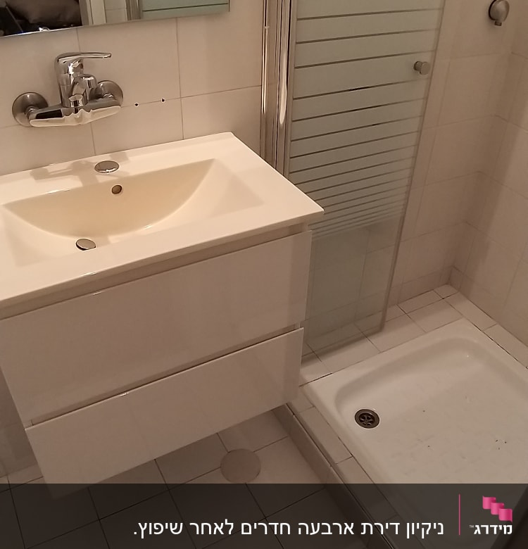 כיור ומקלחון בחדר אמבטיה נקי ומסודר
